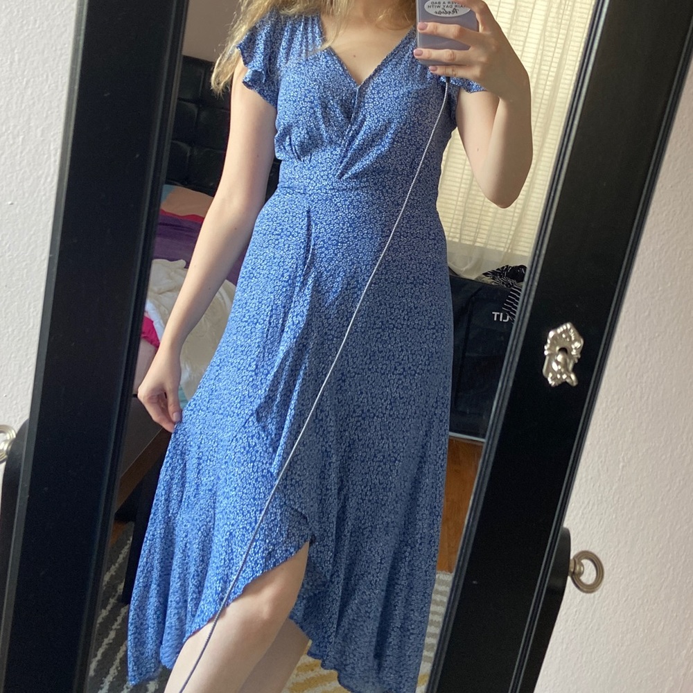 Blue wrap dress with white floral design on it